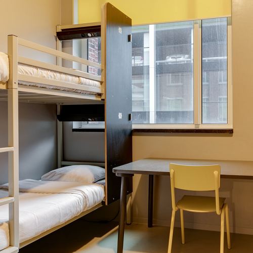 bunk beds, a desk and a chair at ClinkNOORD Hostel in Amsterdam