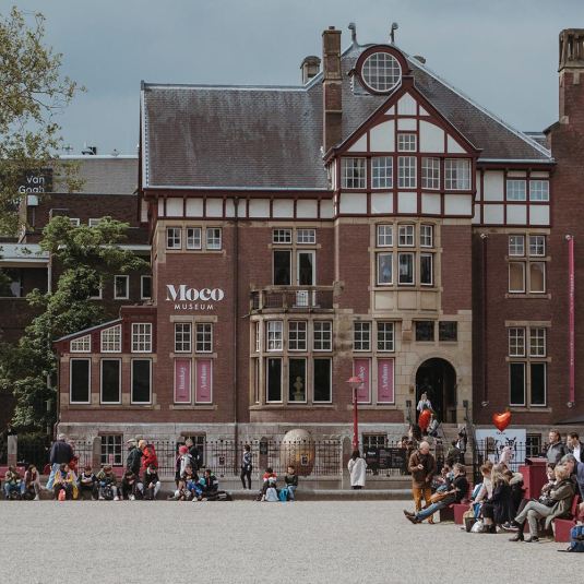 Groups of people gathered outside the Moco Museum in Amsterdam