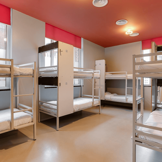 A dorm room in the ClinkNOORD hostel in Amsterdam, with four sets of bunk beds.