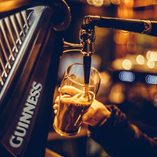 Un serveur de bar verse une pinte de Guinness