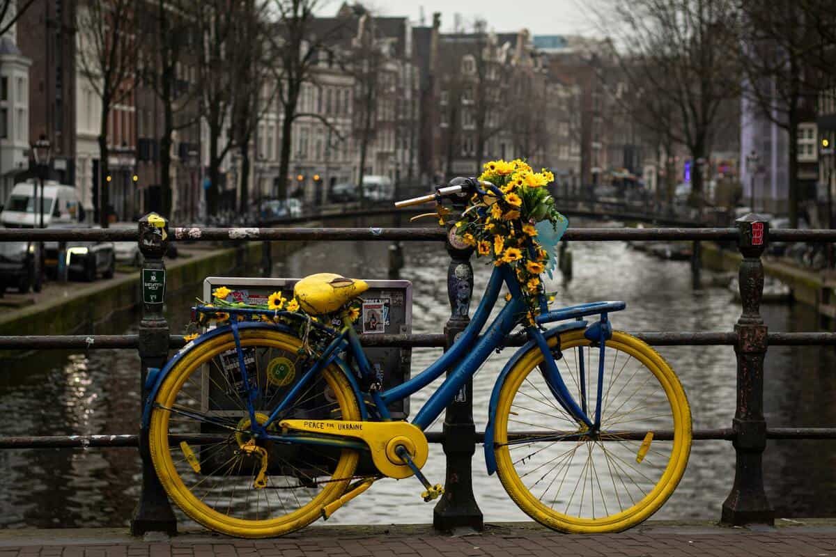 yellow and blue bike in front of a canal in Amsterdam