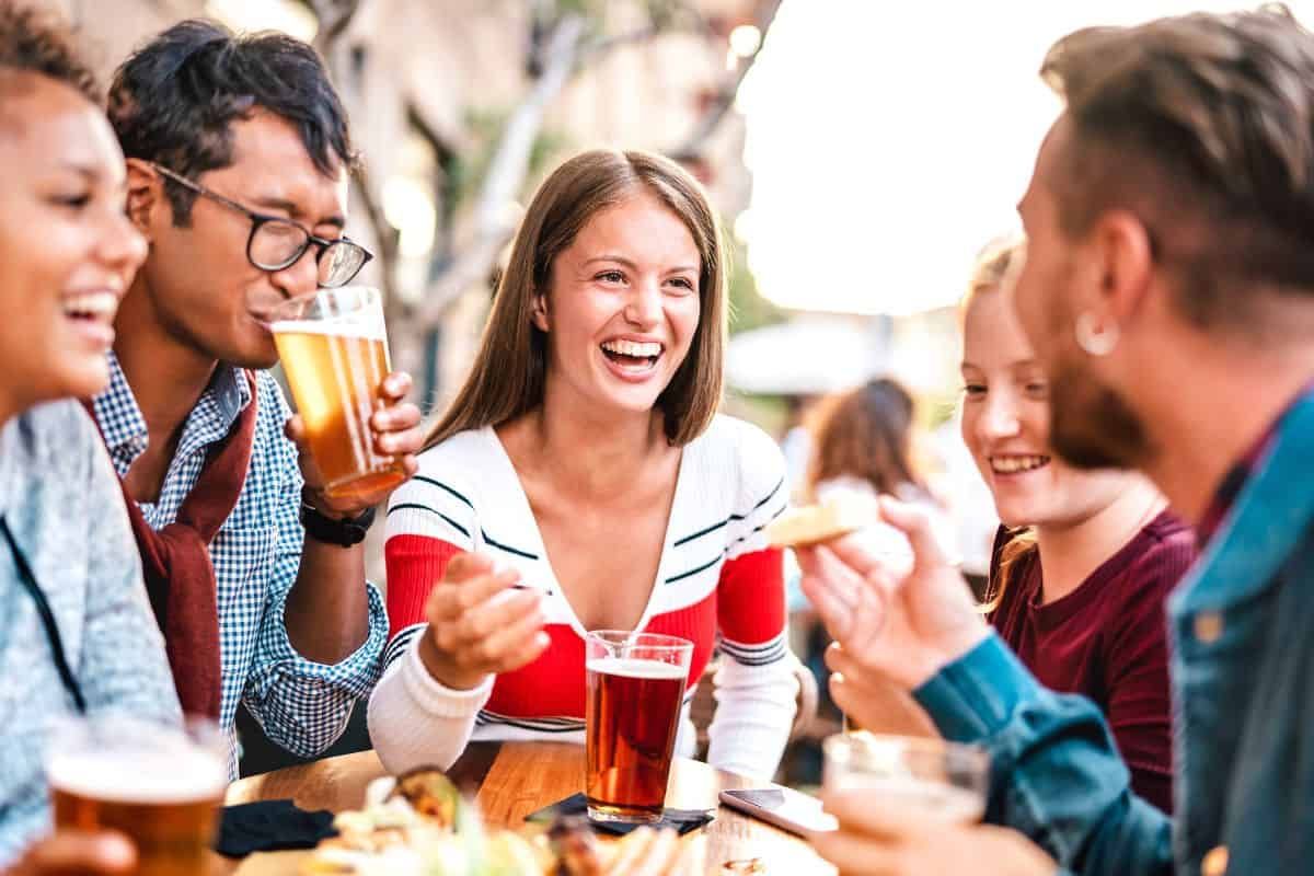 friends enjoying food and drinks on a rooftop bar in london