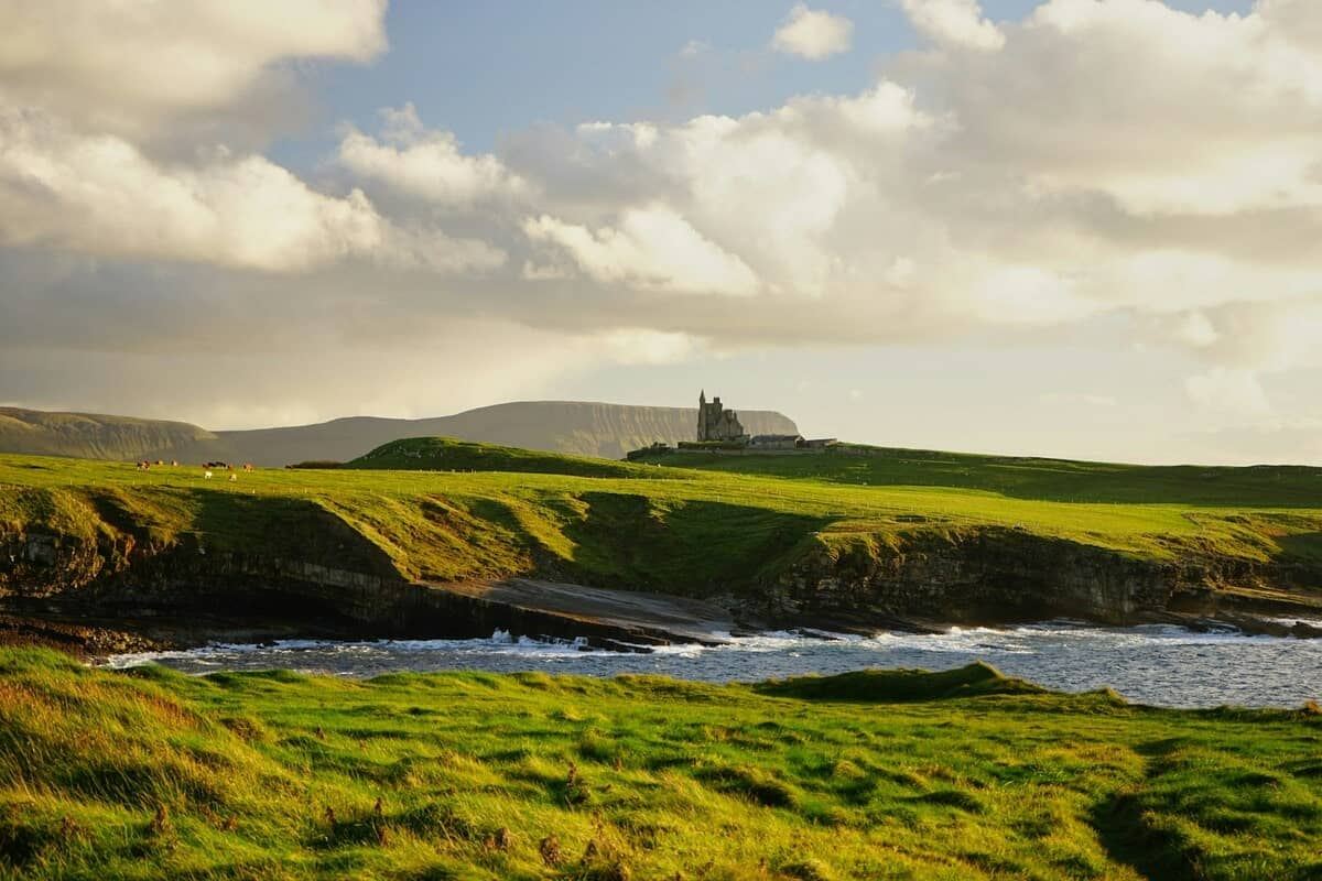 Green landscape of Ireland with a castle in the background