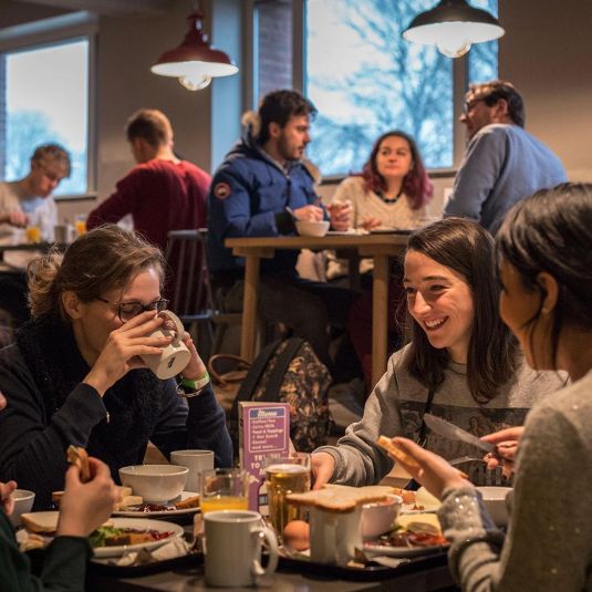 Groups of people eat at Clinknoord hostel 
