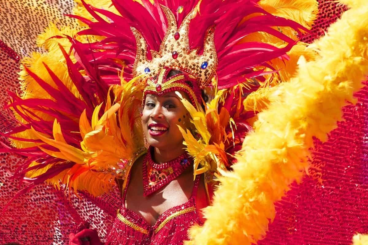 Woman in red and yellow feather costume at the Notting Hill Carnival