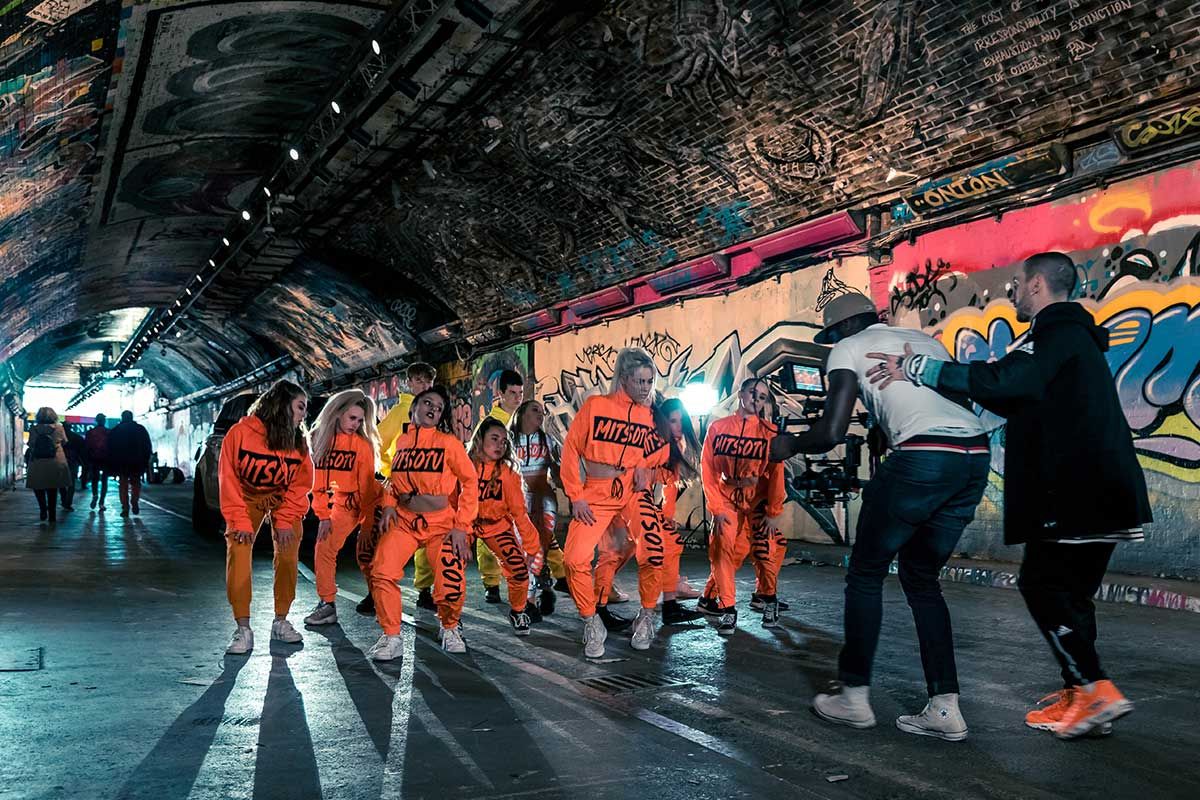 Film crew and dancers on street in London performing a routine