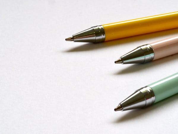 Three pens on white paper
