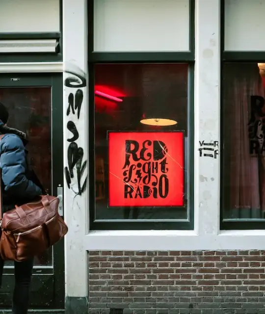 Person mit einer Tasche vor Red Light Radio in Amsterdam