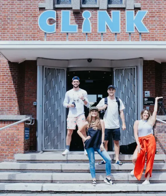 Freunde, die auf den Stufen vor dem Hostel ClinkNoord posieren, Amsterdam