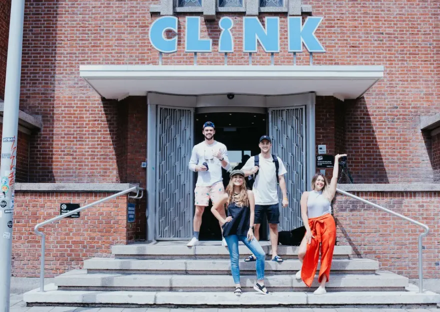 Des amis posant sur les marches devant l'auberge ClinkNoord, Amsterdam