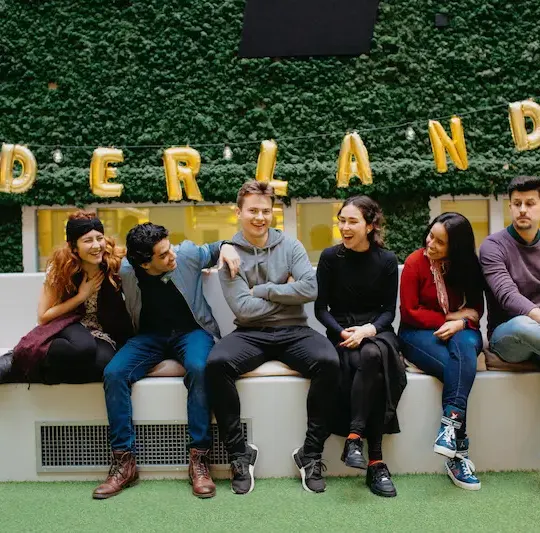 Eine Gruppe Freunde, die auf einer Bank lachen