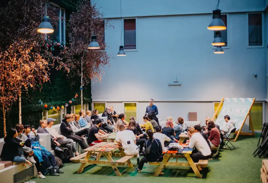 Un grupo en un evento al aire libre en el patio de un albergue Clink