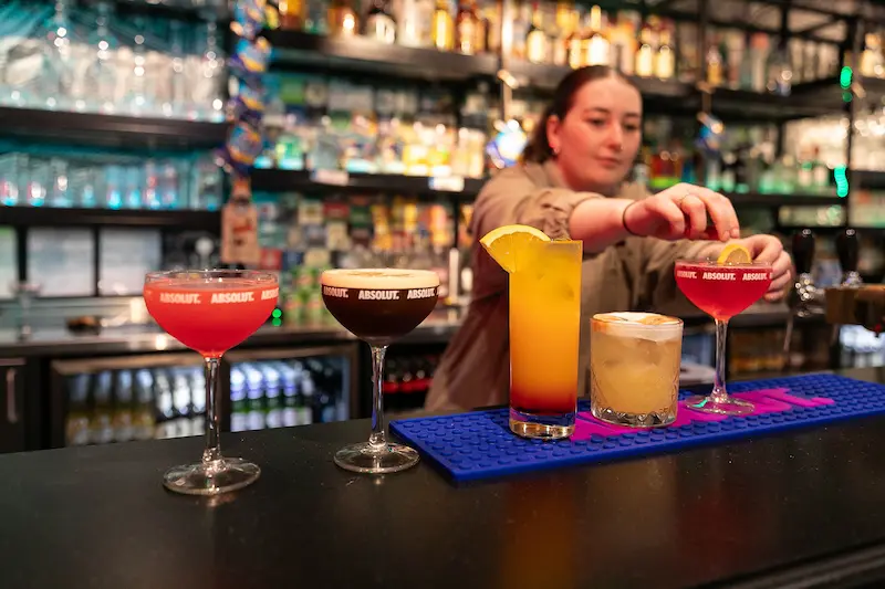 Bartender garnishing a row of cocktails at the Clink i Lar bar, Dublin