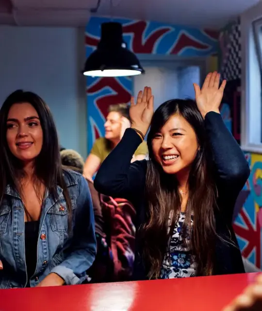 Deux amis riant dans la salle commune colorée de l'auberge Clink261, Londres