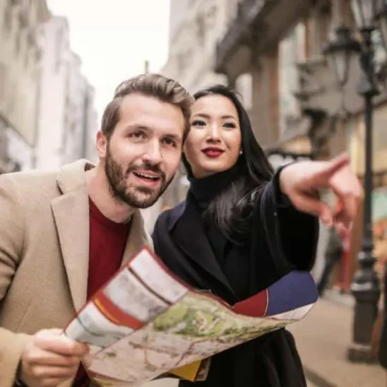 Women directing a man a man holding a map.