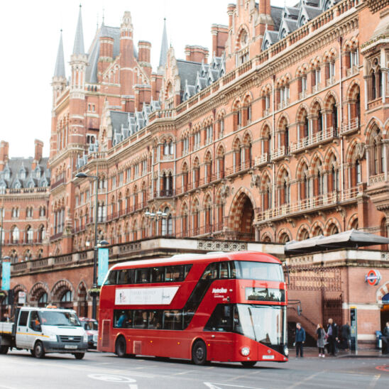 A red London double-decker bus outside King's Cross / St. Pancras station.