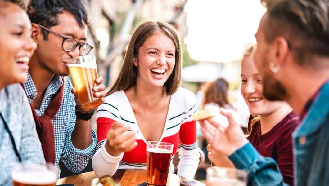 friends enjoying food and drinks on a rooftop bar in london