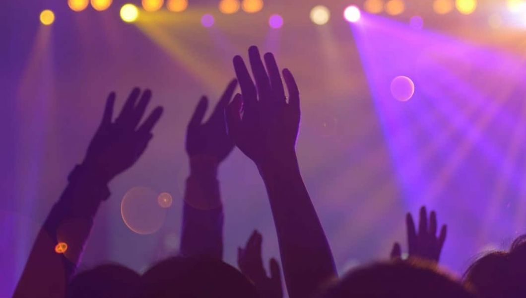People raising their hands in a club
